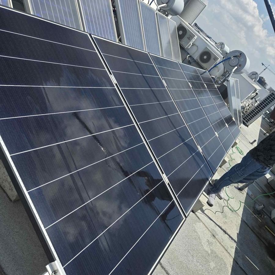 Solar panels being cleaned on a rooftop
